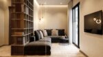 Silk Plaster Relief 323 in warm sand on a living room wall with a dark grey corner sofa