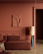 PrimeColor 5 tinted B35 terracotta living room wall with abstract relief art and a tall cylinder floor lamp