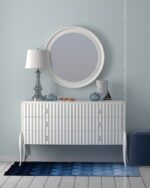 PrimeColor 5 tinted B12 pale blue wall behind a white fluted dresser with a round mirror