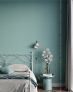 PrimeColor 5 tinted B34 teal blue-grey bedroom wall with a white metal bed frame and a round side table