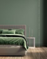 PrimeColor 5 tinted B16 sage green bedroom wall with green bedding and a round bedside table