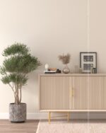 PrimeColor 5 tinted B1 pale beige on a wall behind a fluted beige sideboard with gold legs and an olive tree