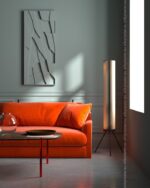 PrimeColor 5 tinted B9 pale grey-green living room wall with an orange velvet sofa and a tall cylinder floor lamp