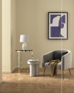 PrimeColor 5 tinted B32 pale khaki cream wall with a gold side table, ottoman, grey armchair and navy abstract art