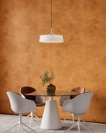 Nappa velvet-touch wall paint in warm ochre, dining area with a round glass table and tan chairs