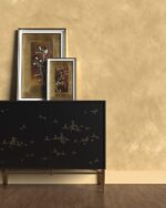 Nappa velvet-touch wall paint in golden ochre above a black sideboard with gold-framed prints