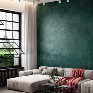 Nappa velvet-touch wall paint in deep green, living room with a beige modular sofa and red throw