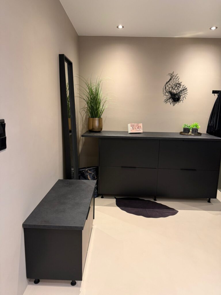 Completed microcement bathroom in Norway - backlit round mirror, black vessel basin, and wooden vanity by Gediminas