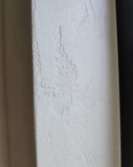 Travertino Naturale lime plaster wall detail with natural light highlighting the textured mineral surface — Silk Plaster