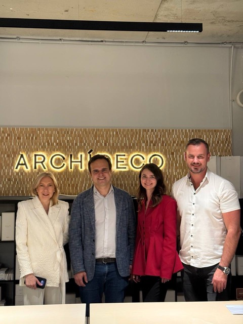 Silk Plaster and Archideco Riga leadership team at the showroom, in front of the gold Archideco wall