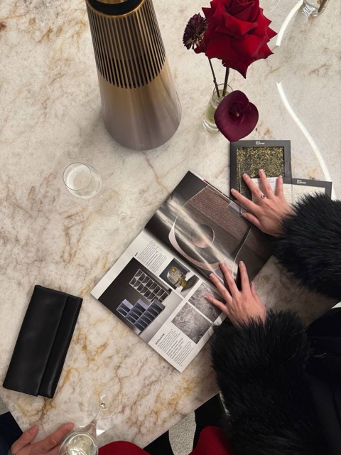 Archideco Designer's Library magazine open on a marble table with a gold vase and rose
