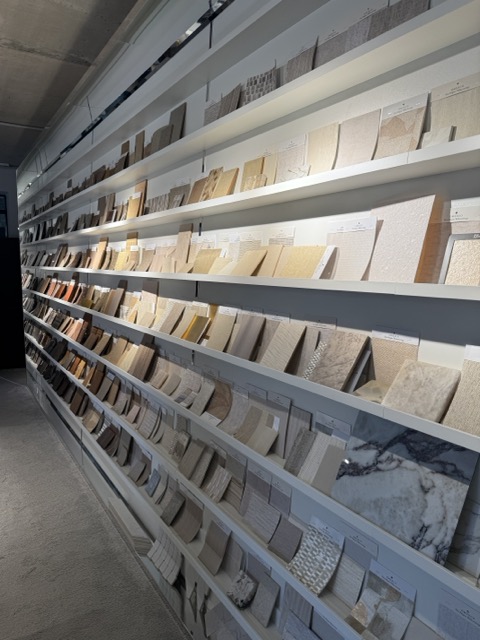 Silk Plaster liquid wallpaper and decorative plaster samples on the illuminated display wall at Archideco Riga