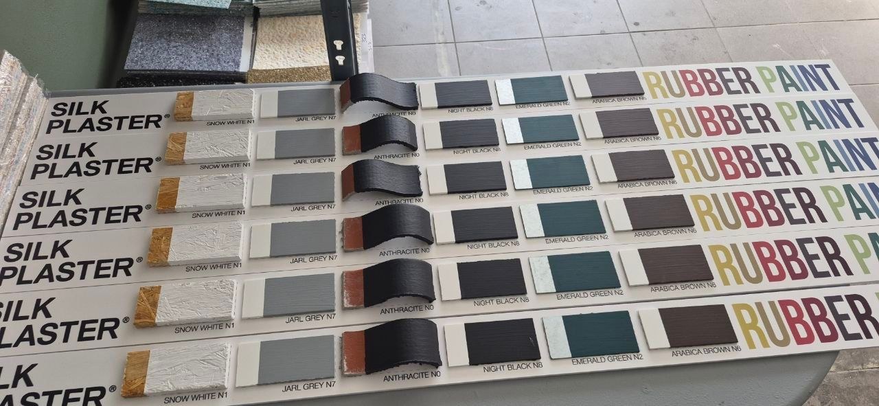 Close-up of Rubber Paint display boards with painted colour samples on timber, metal and roofing profile