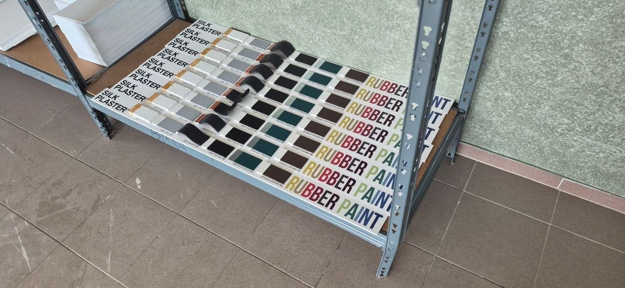 A batch of finished Rubber Paint display stands stacked on a shelf ready for shipping