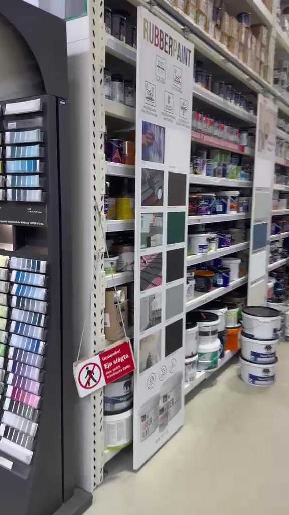 Tall Rubber Paint display board mounted at the end of a paint aisle in a DIY store